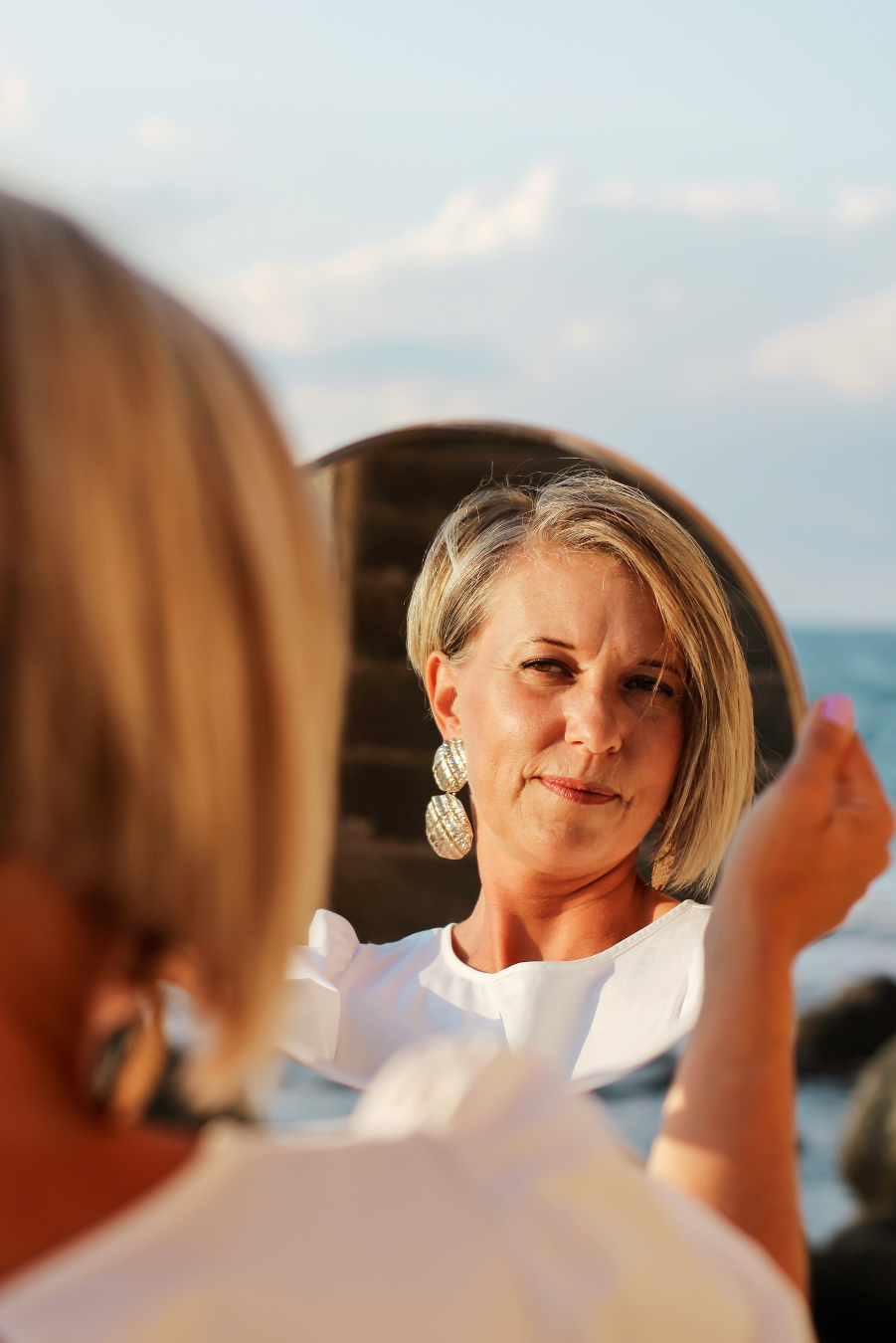 woman looking at her own reflection in a mirror