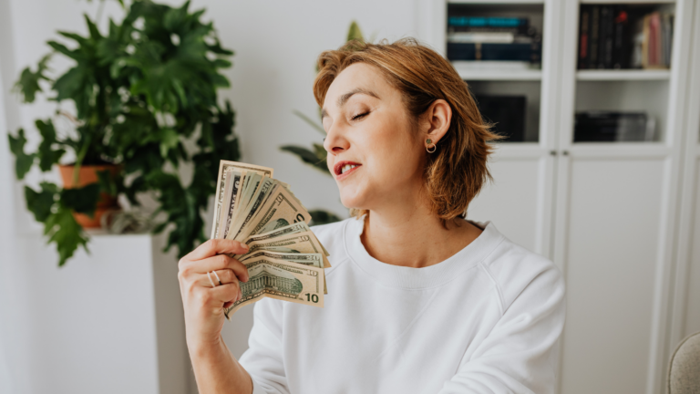 Woman fanning herself with money cash confidence