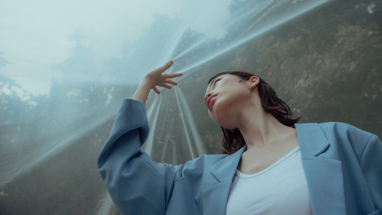 Woman stuck under tarp that represents her limiting money beliefs